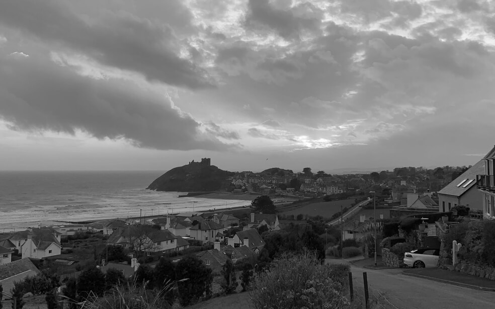 Fotografía en blanco y negro de una ciudad natal al lado del mar.